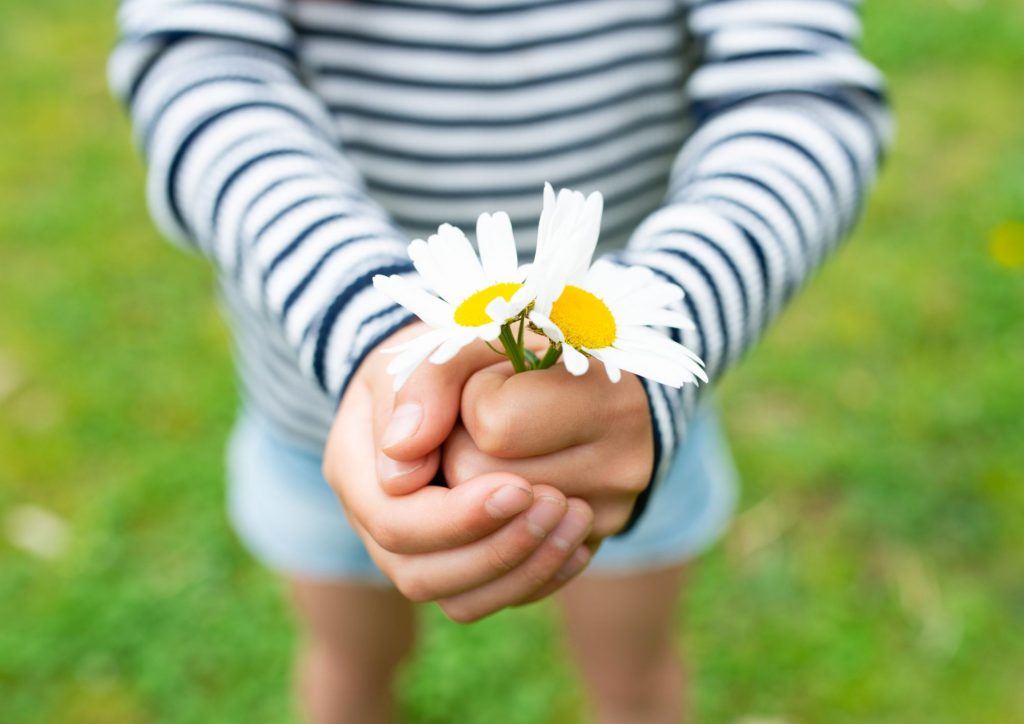 enfant qui offre des fleurs en cadeau 