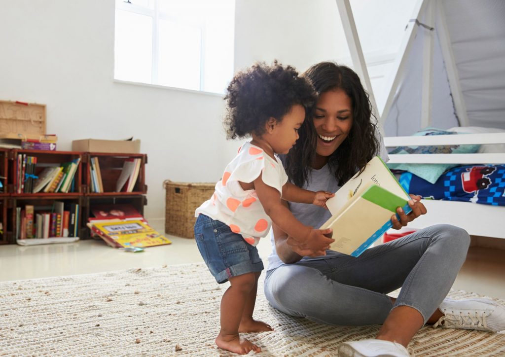 parent qui lit un livre à son enfant pour développer le goût de lire