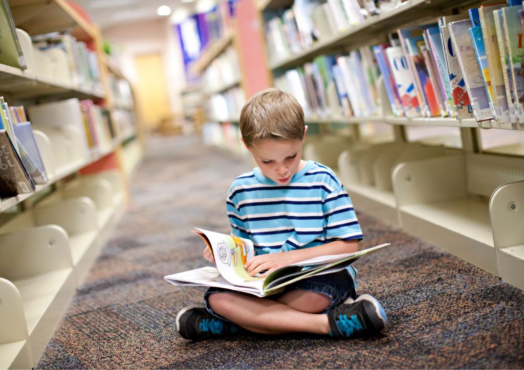 enfant qui lit à la bibliothèque
