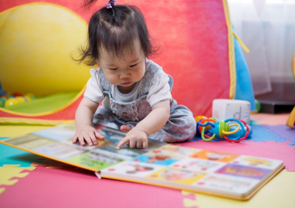 bébé qui lit un livre grand format