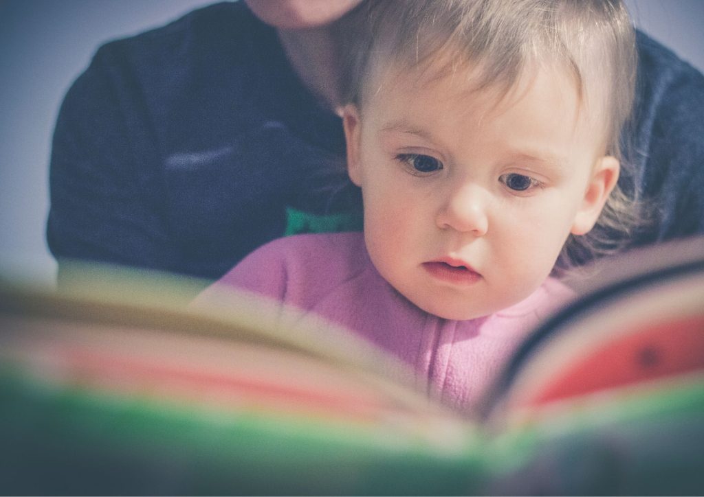 bébé qui lit avec un adulte des livres