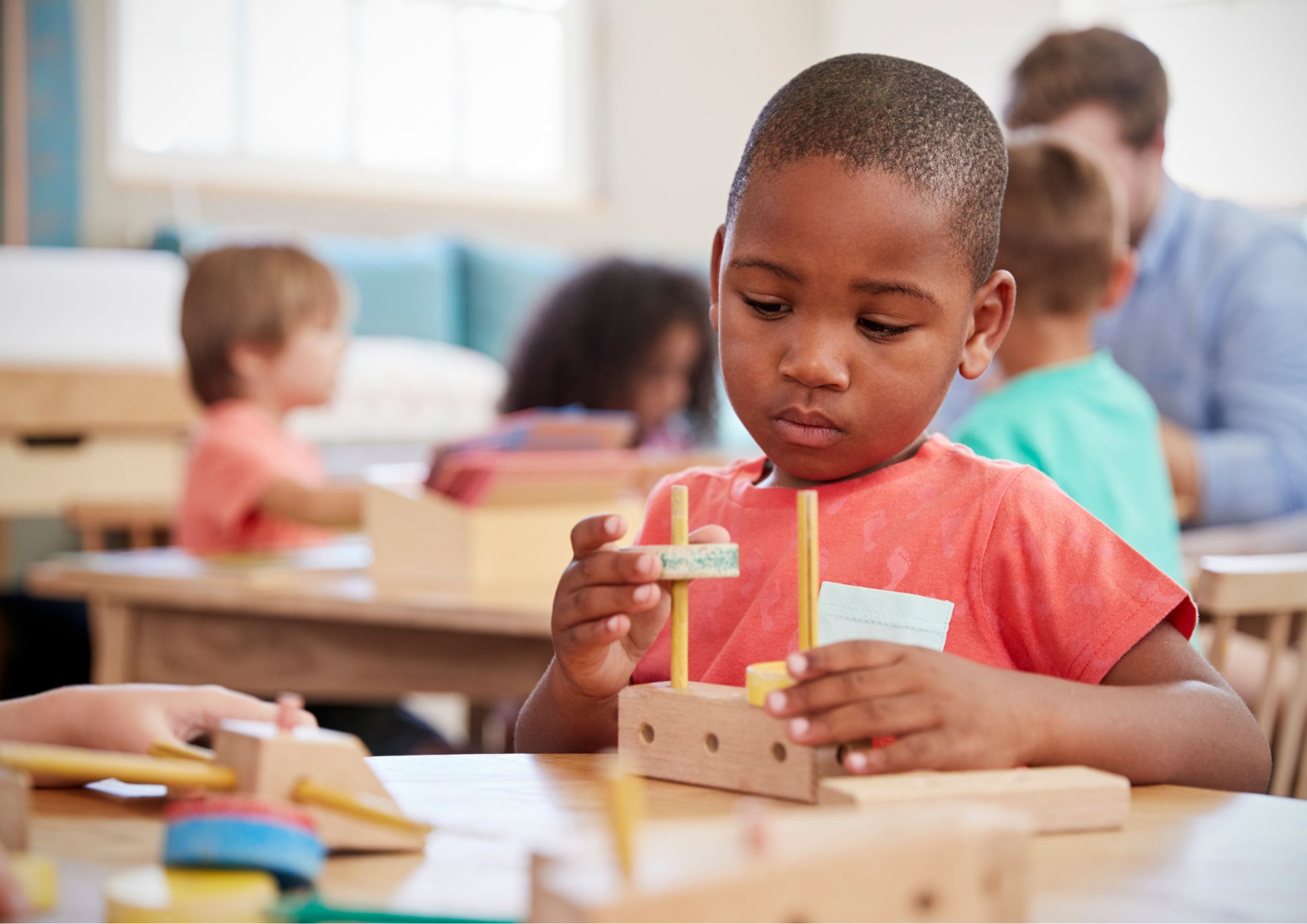 enfant manipulant un jouet en bois Montessori à l'école