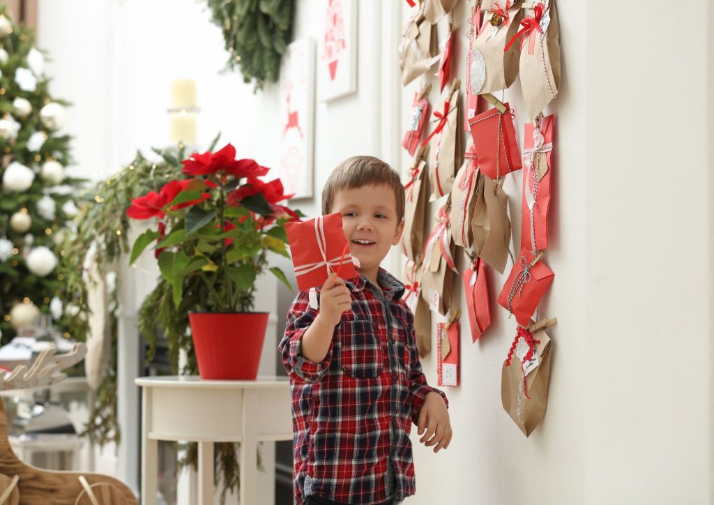 enfant ouvrant un calendrier de l'Avent fabriqué maison