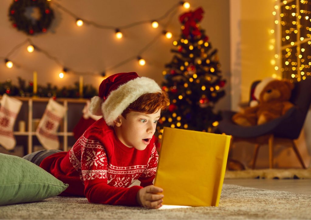 enfant lisant un livre dans un décor de Noël