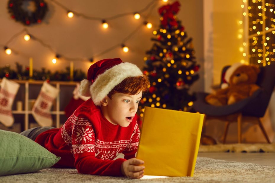 enfant lisant un livre dans un décor de Noël