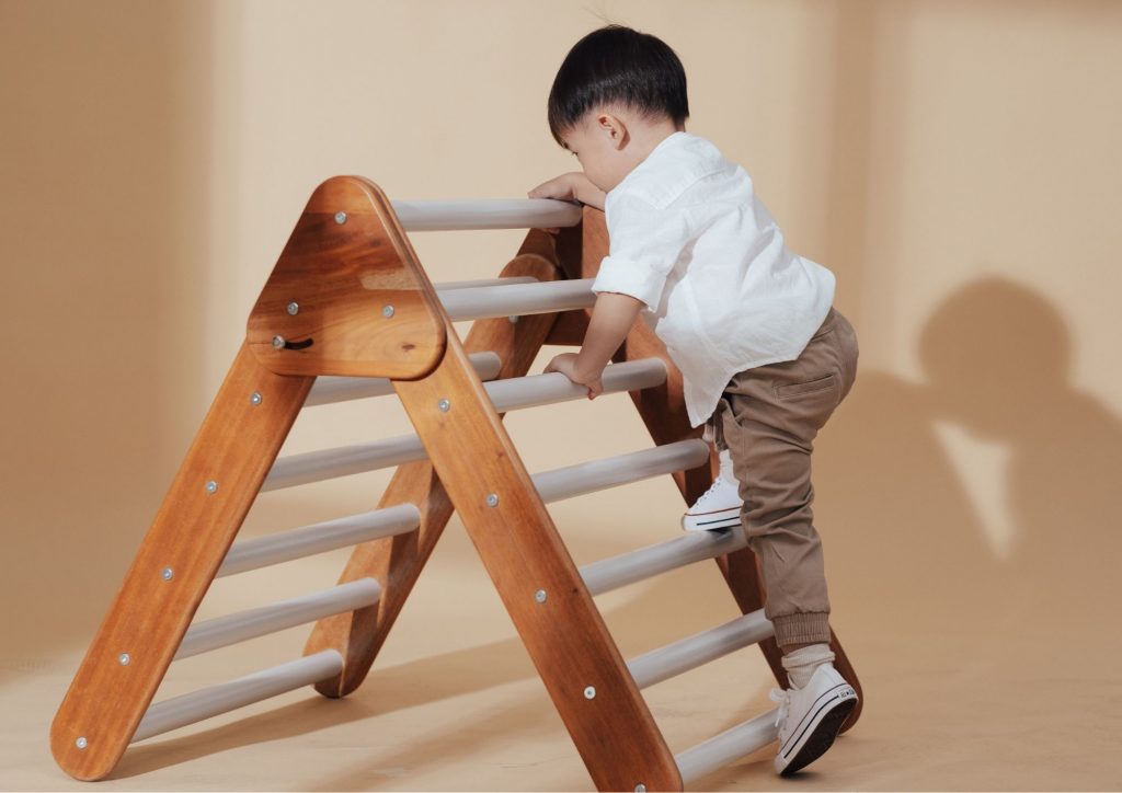 enfant de 2 ans escaladant une tour de motricité