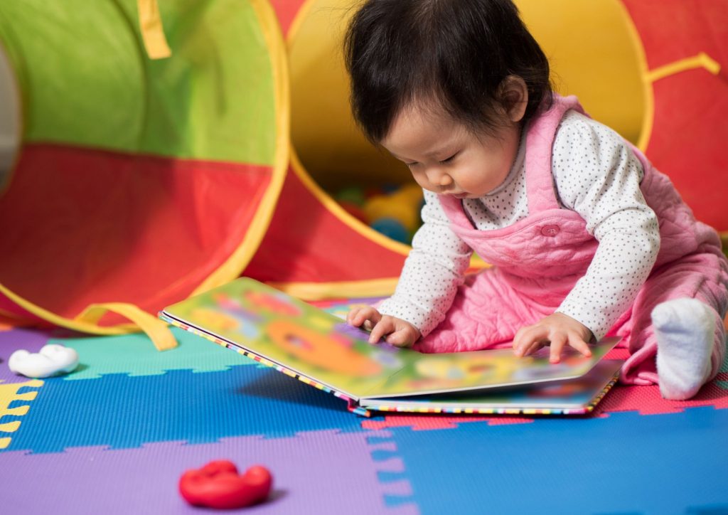 Bébé qui lit par terre dans le coin lecture