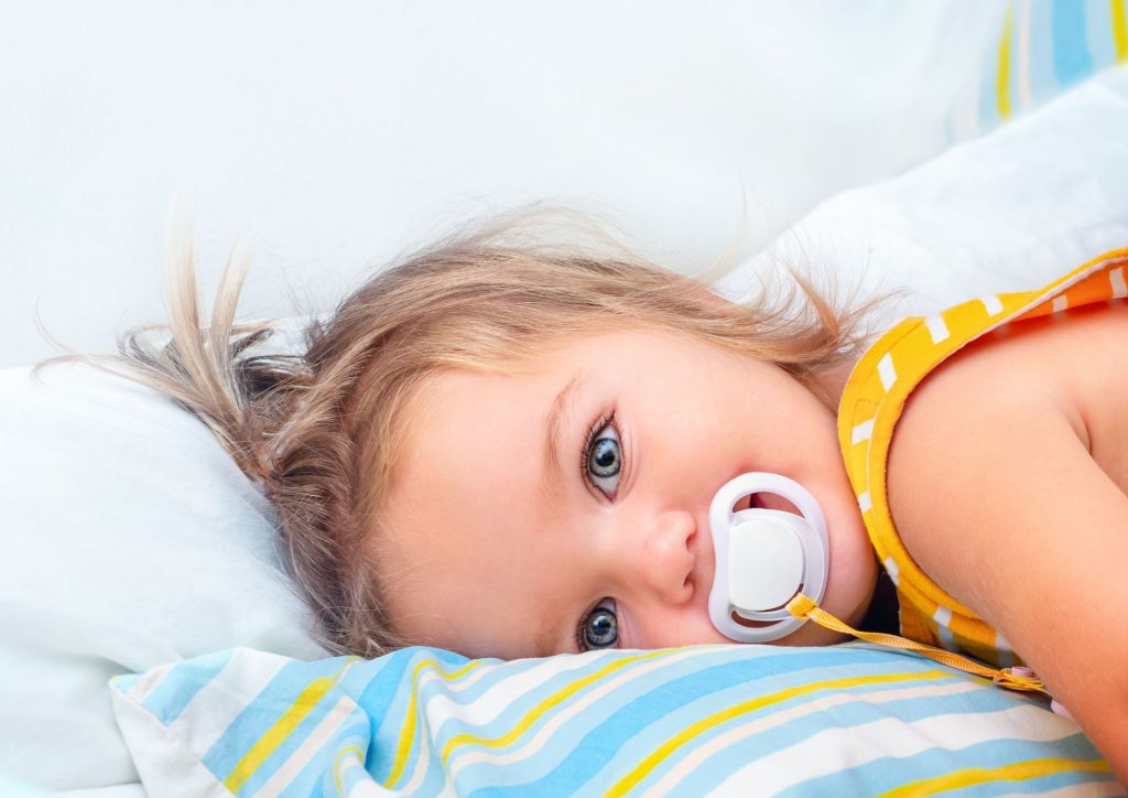 enfant couché avec sa tototte