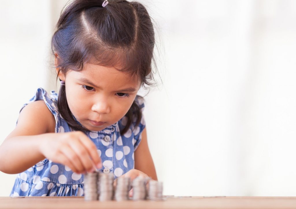 enfant qui compte des pièces de monnaie