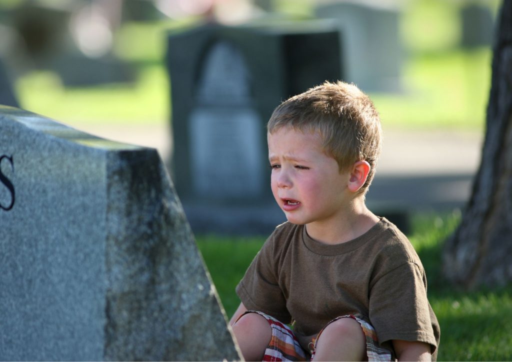 enfant qui pleure sur une tombe