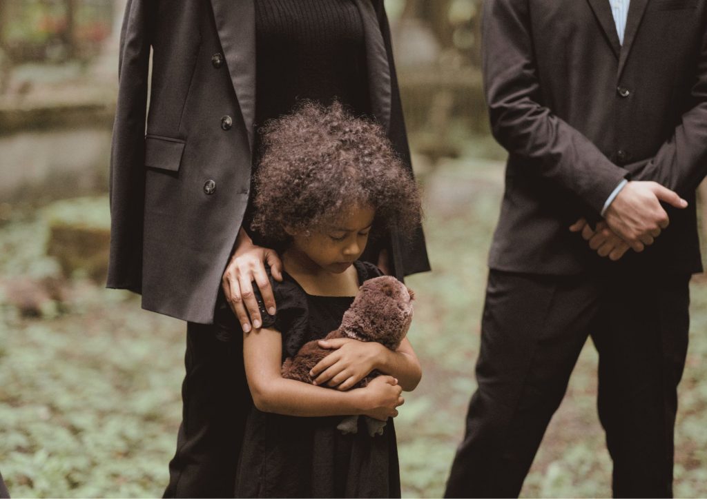 enfant triste qui assiste à un enterrement