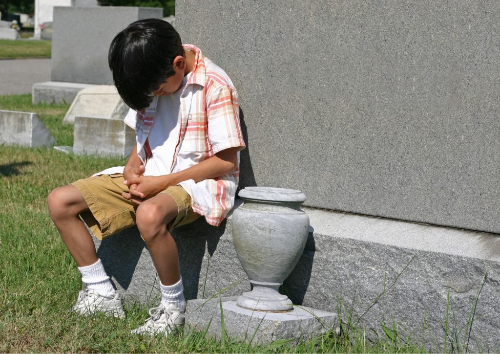 enfant dans un cimetière après la mort d'un proche