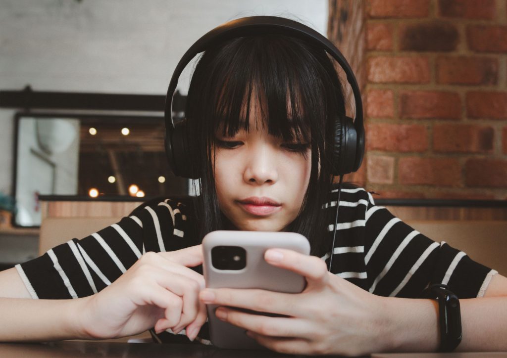 adolescent avec son smartphone, un des équipements numériques les plus fréquents chez les jeunes