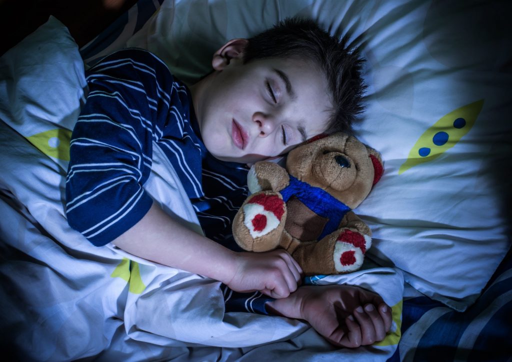 enfant qui dort avec son doudou ©Canva Pro