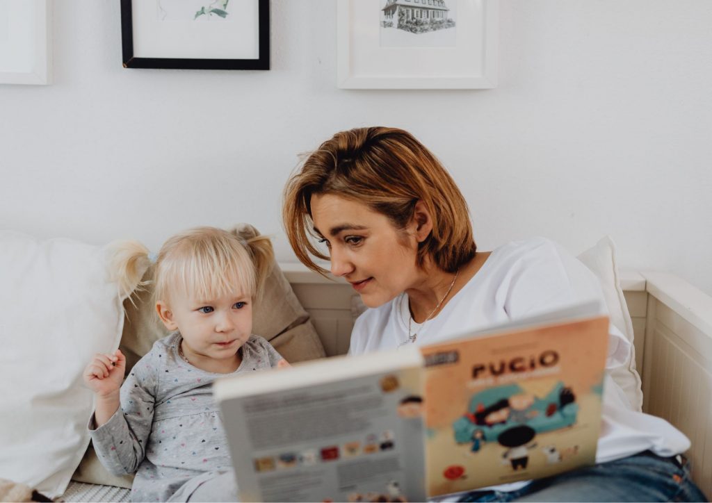 parent qui lit un livre à son enfant avant le coucher ©Canva Pro