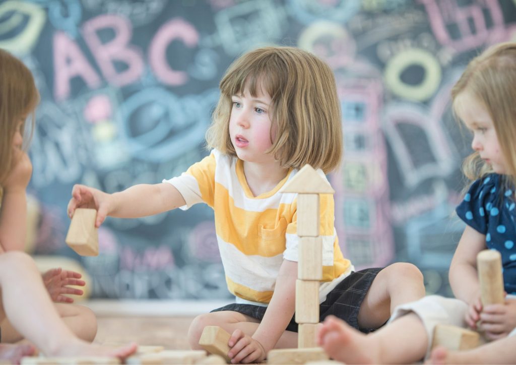 enfant qui prête un cube