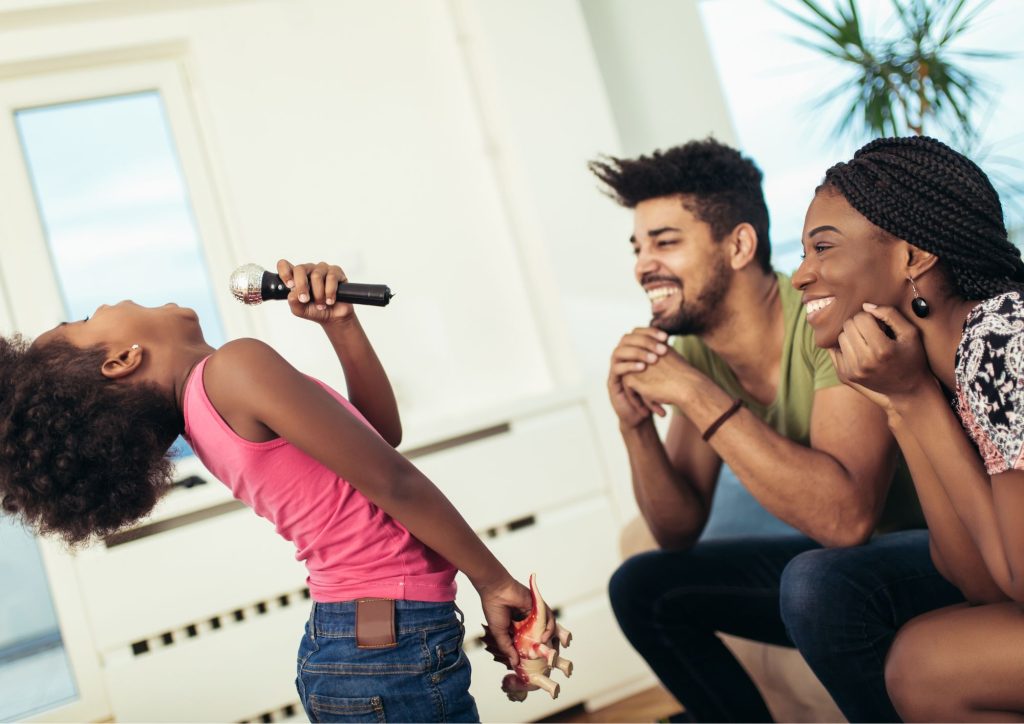 exprimer ses émotions en famille enfant qui chante devant ses parents ©Canva Pro
