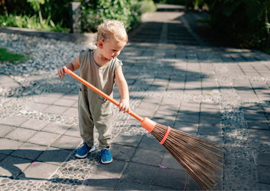 enfant qui balaie les feuilles mortes gérer la frustration par l'autonomie