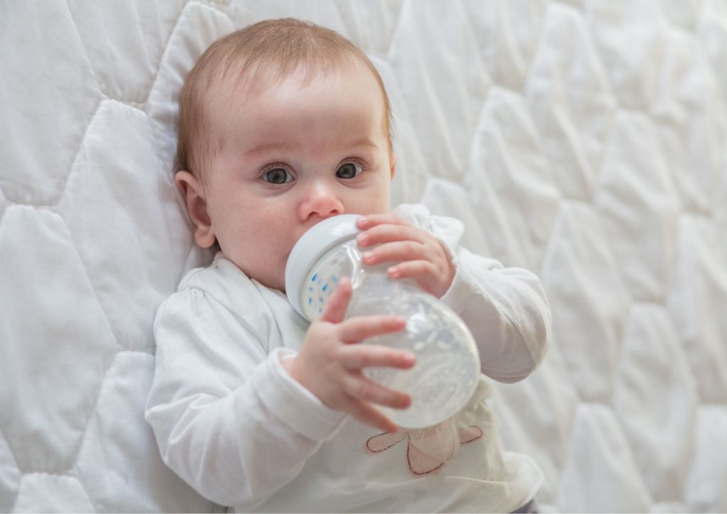 bébé qui boit son biberon tout seul