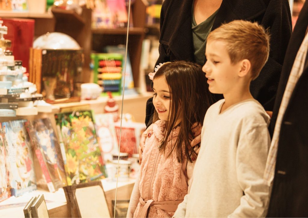 enfants qui regardent des BD en vitrine